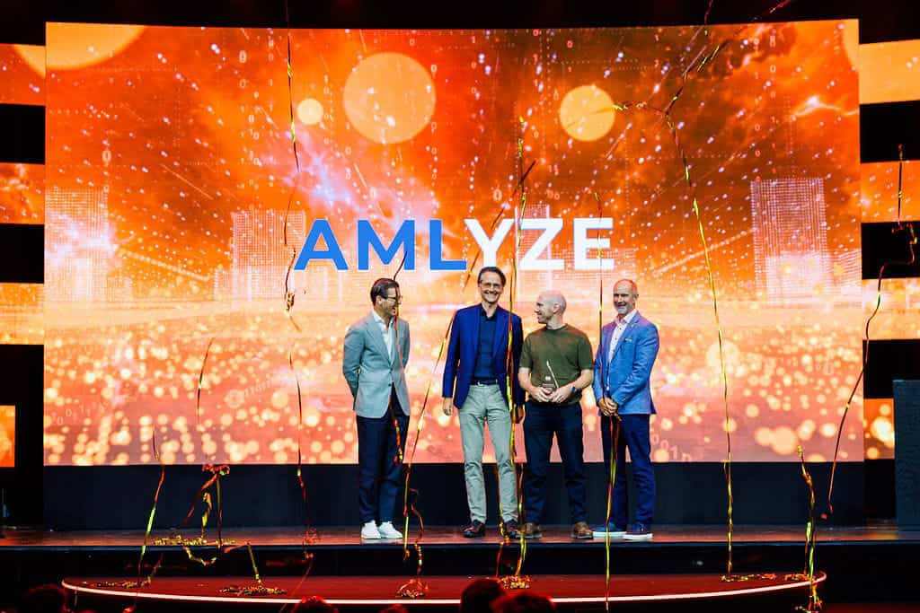 AMLYZE technology conference with executives on stage at a corporate event.